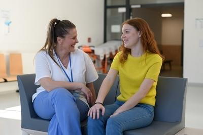 Doctor talking to a adolescent woman on sofa