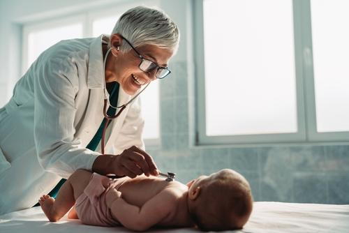 Pediatrician examining and caring for a newborn baby in a clinical setting