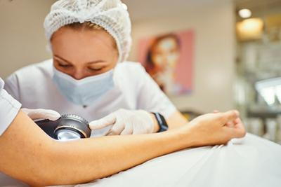 skin specialist examining patient for dermatologic concerns