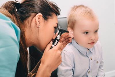 Toddler receiving ear examination from pediatrician