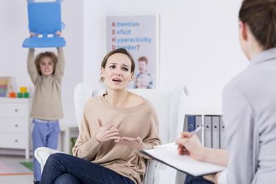 Illustration of ADHD kid in the background with mother and therapist