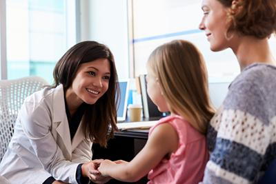 Pediatrician meeting little girl and mom for routine child care