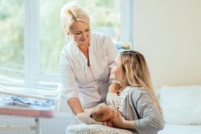 New mom receiving guidance on proper breastfeeding techniques from a specialist