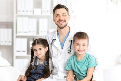Doctor with young boy and girl beside him