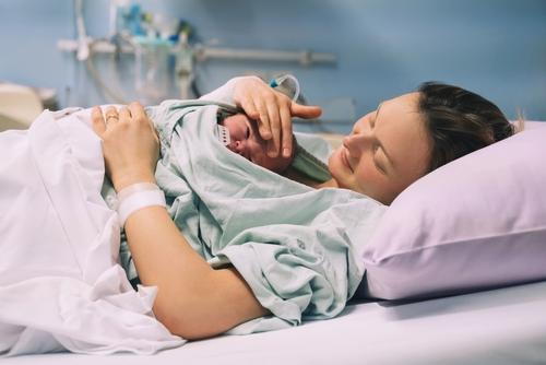 Mother pampering her newborn baby in her chest