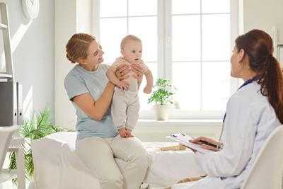 Developmental screening with a pediatrician as mother holds her baby.