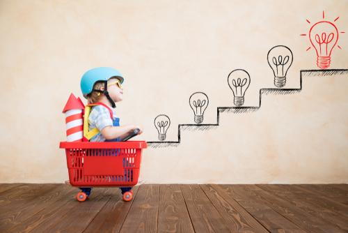 Child riding a cart designed like a rocket, representing developmental milestones.