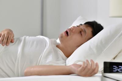 Man with Sleep Apnea on bed