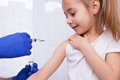 Pediatrician administering vaccine to young child in medical office