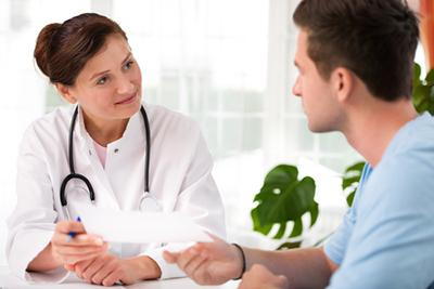 Doctor talking to a young man in teen on clinic