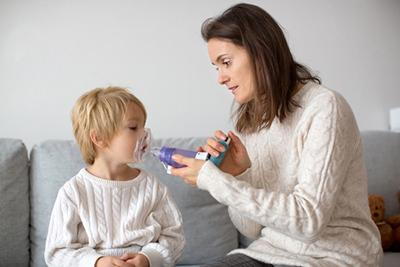 Mother helping child manage asthma with inhaler
