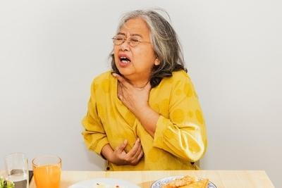 Seniors in yellow clothes having difficulty in swallowing
