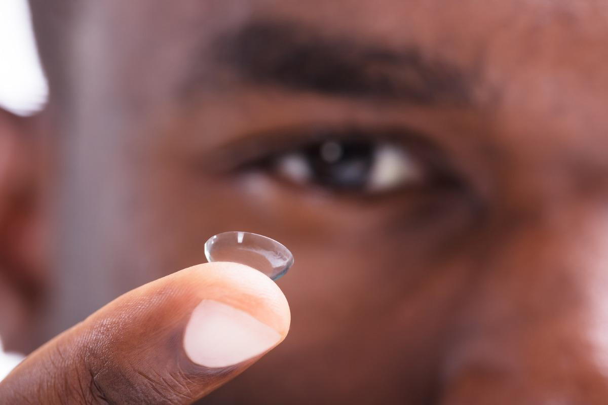 man holding a contact lens