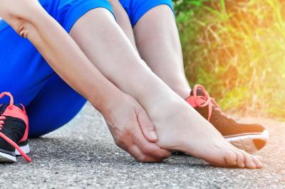 Person in blue workout gear holding sore foot