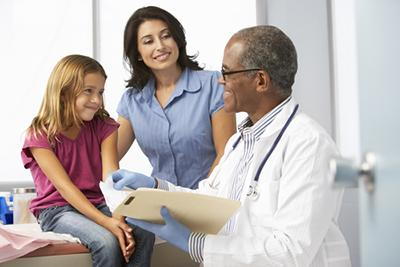 Young talking to the doctor with her mother on clinic