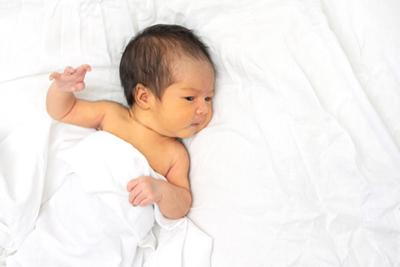 Infant with neonatal jaundice lying under soft blanket