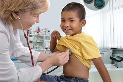 Pediatrician checking the heartbeat of a young boy on clinic.