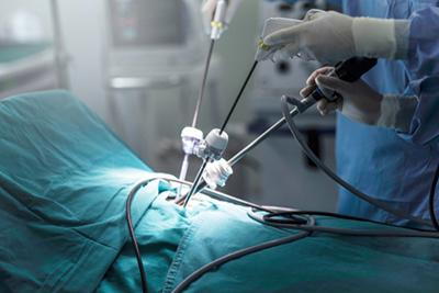 Gynecologic surgeon using laparoscopic tools for minimally invasive hysterectomy