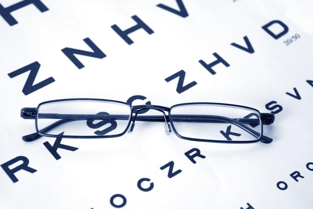 Eyeglasses on top of an eye exam chart