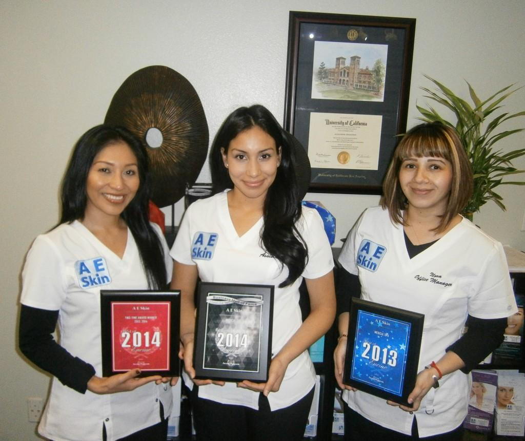 Cedilia, Karla, and Nora display the A E Skin Best Medical Spa in Encino awards for 2013 and 2014