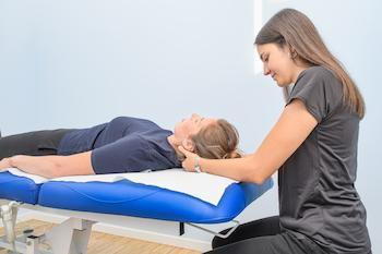 female chiropractor doing neck and spinal adjustment on patient