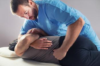 chiropractor doing spinal adjustment on a man's back