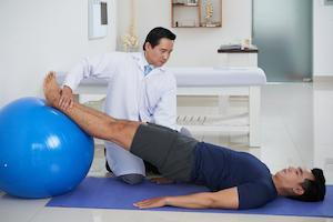 patient doing exercises with chiropractor for knee pain management targeting both spine and knee
