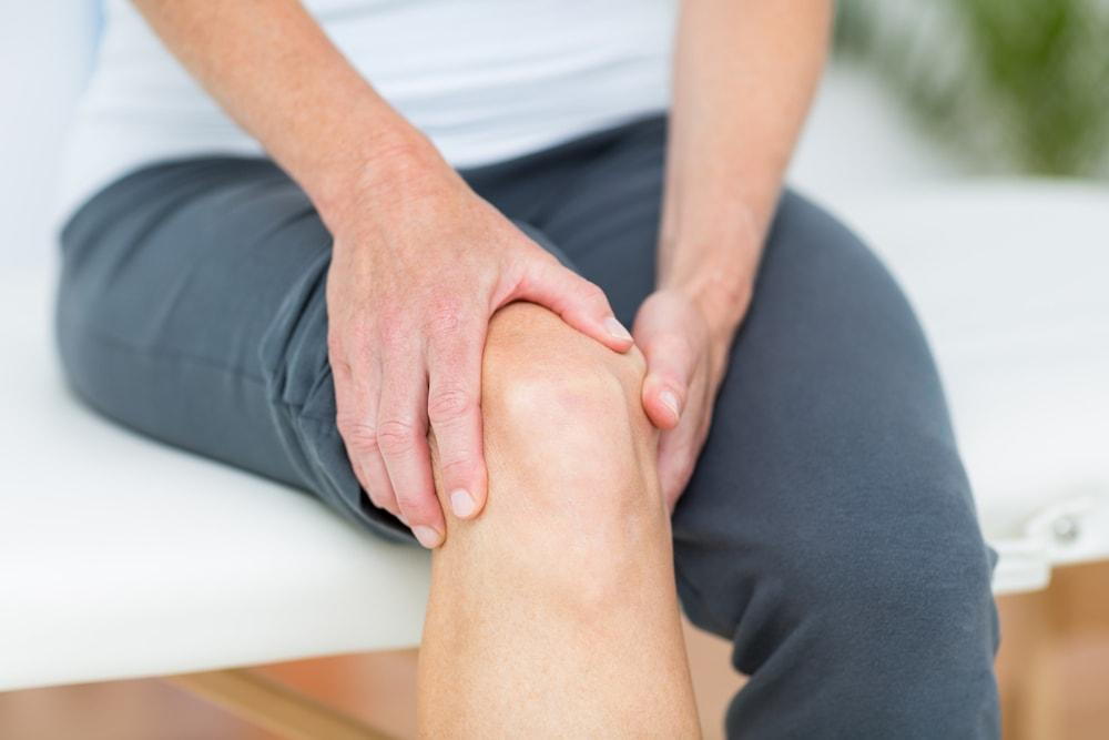 Man holds his knee in pain after a car accident