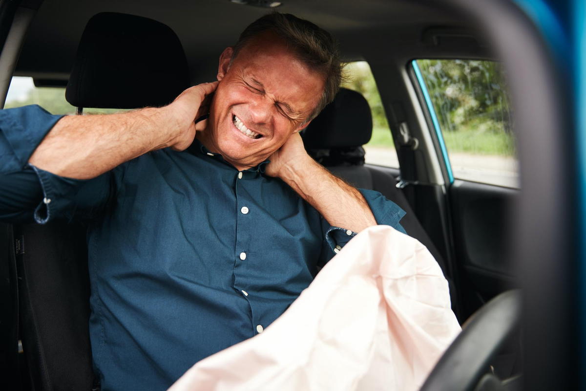 middle aged man holding his neck due to a recent car accident injury