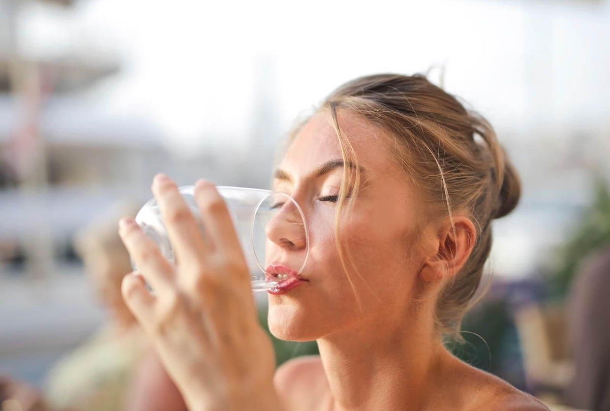 woman drinking water after chiropractic adjustment