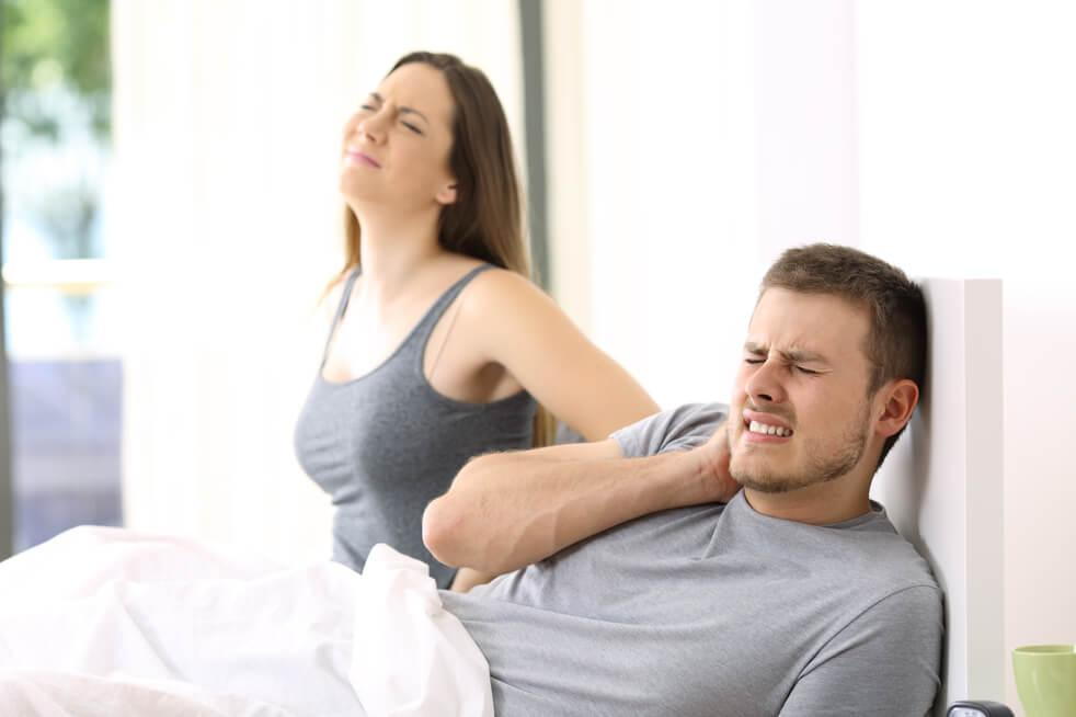 couple in bed wondering “should i see a chiropractor”