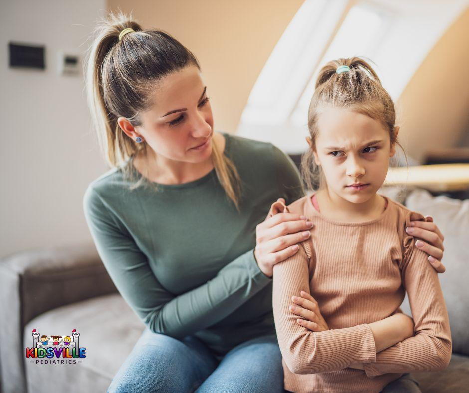 1. Woman holding little girl's arm on couch. 2. Mother and daughter sitting together on sofa. 3. Female adult and child sitting on couch.