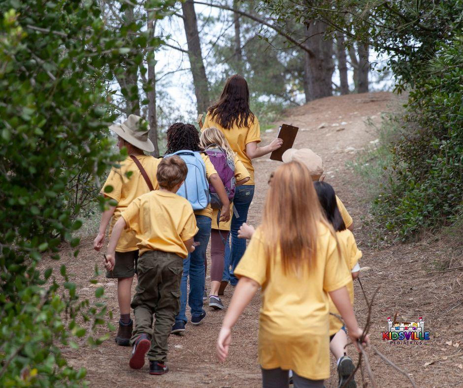 A group of children walking down a trail, enjoying nature's beauty and exploring the great outdoors.