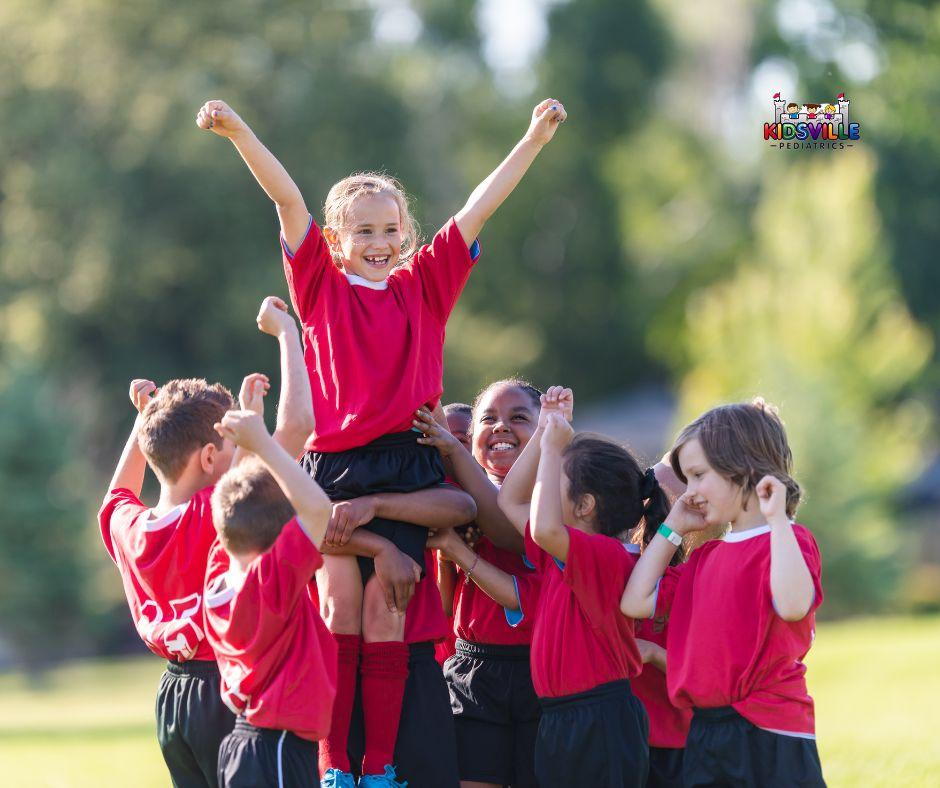 A joyful group of children wearing red shirts, happily celebrating a special sports win.