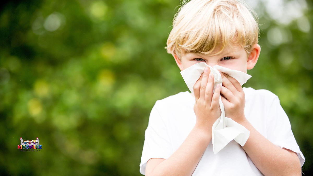 A young boy blowing his nose into a tissue.