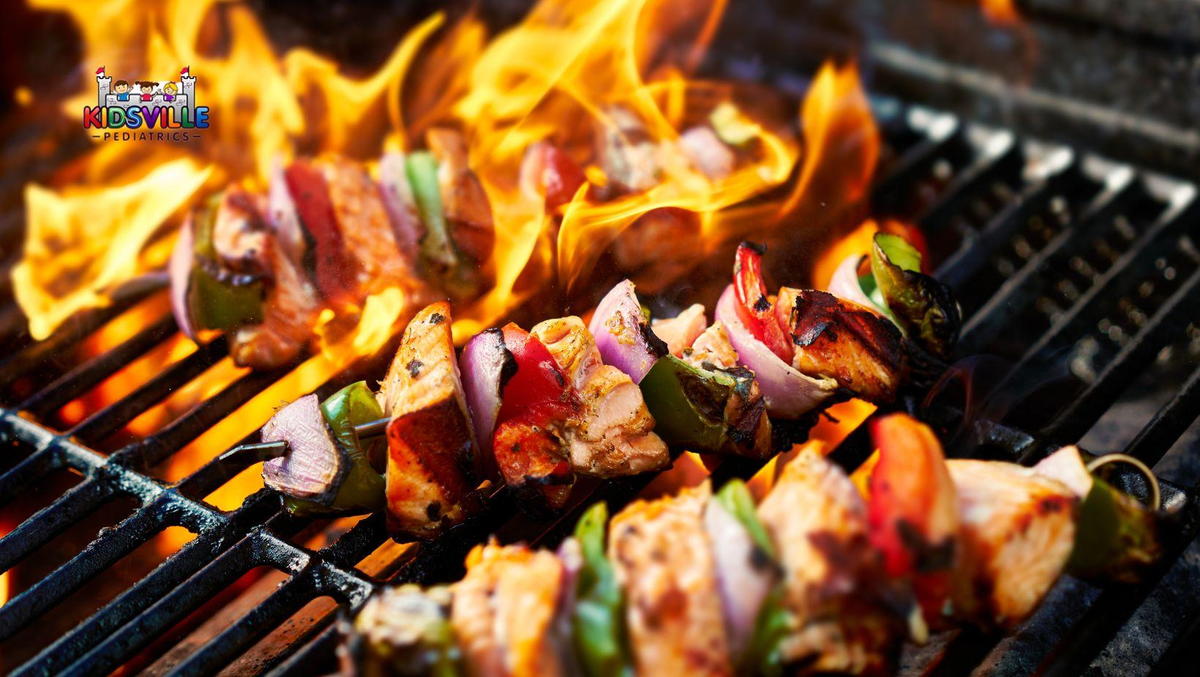 Grilled chicken and vegetable kebabs cooking on a flaming grill.