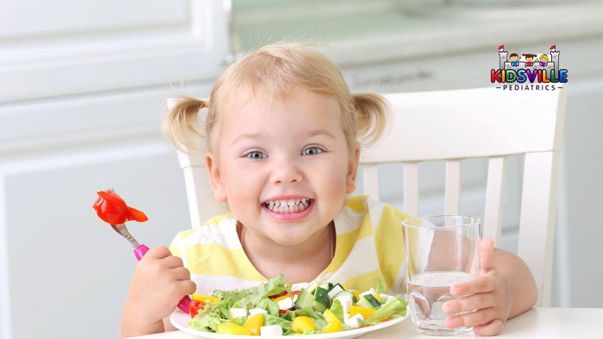 A smiling young girl proudly displays a vibrant plate of salad, showcasing her healthy choice.