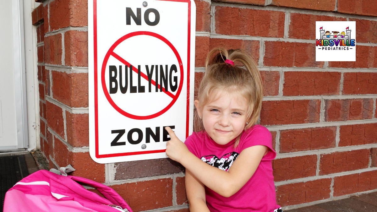 A young girl leans against a brick wall, displaying a no bullying sign, promoting a message of kindness and respect.