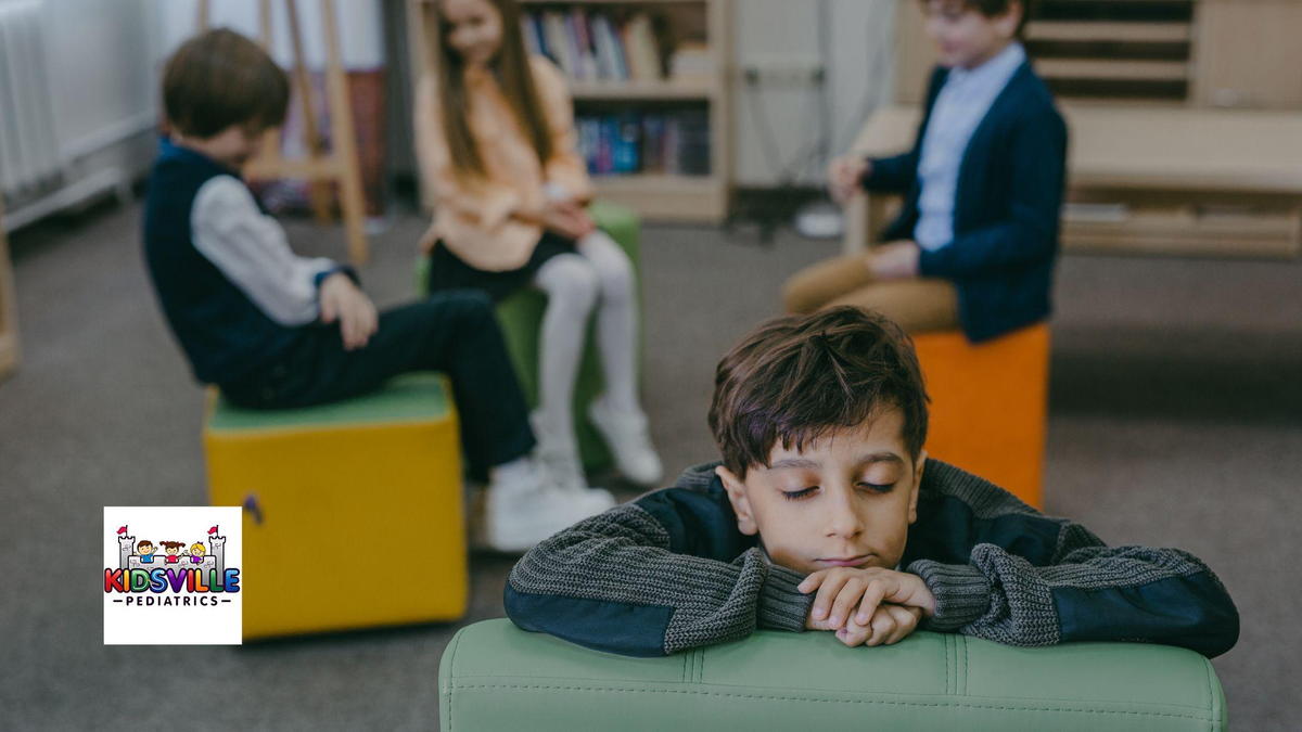 A socially isolated boy, with his classmates talking behind him.