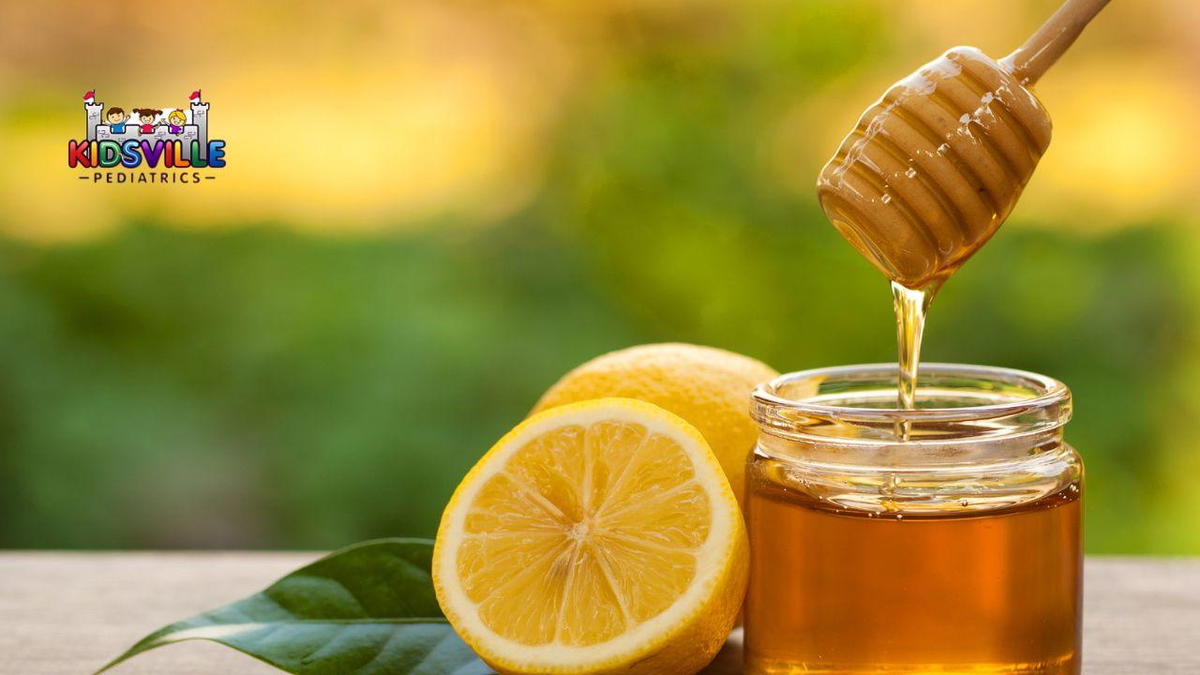 A close-up of a jar of honey beside a sliced lemon, with fresh lemon juice in a small glass, highlighting natural ingredients.