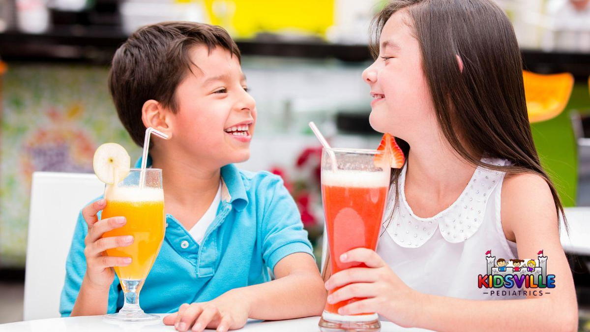 Two children sitting at a table drinking sugary beverages.