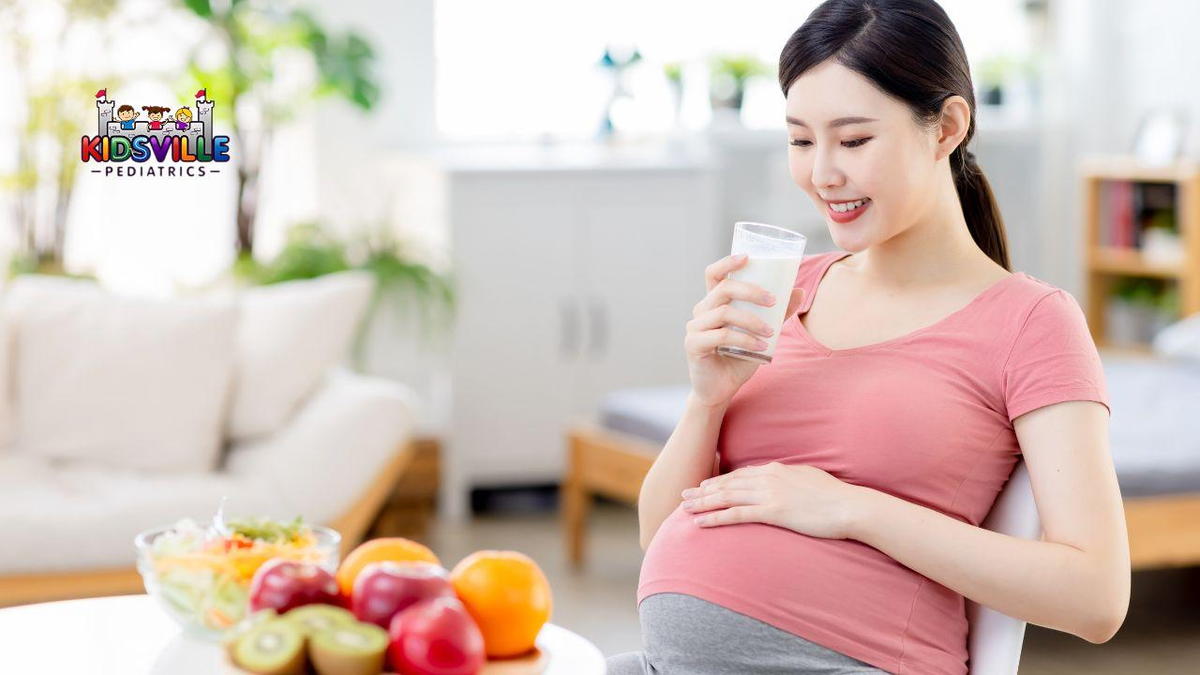 Pregnant woman enjoying a glass of milk while eating fresh fruit, promoting a healthy lifestyle for her and her baby.