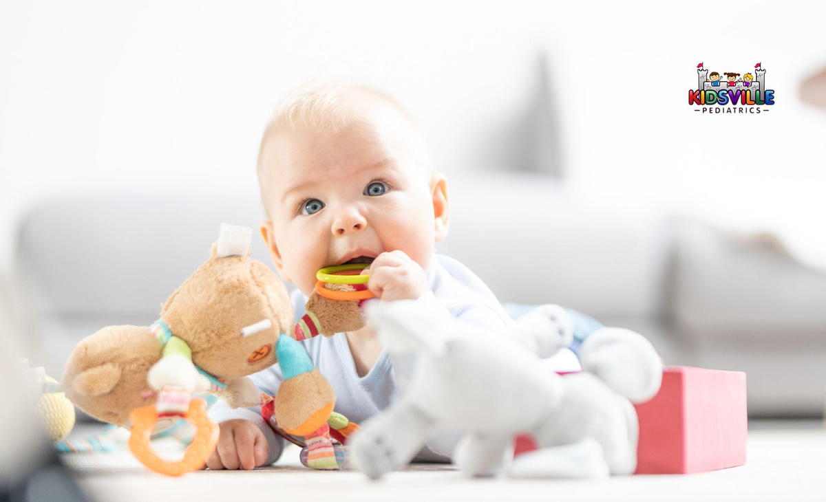 A baby happily plays with colorful toys scattered on the floor, showcasing joy and curiosity in a bright environment.