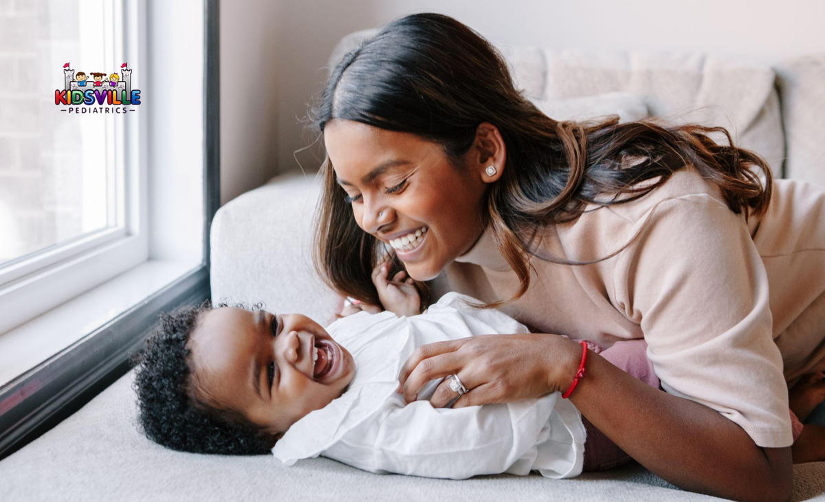 A joyful woman smiles warmly as she cradles her baby boy in her arms, showcasing a moment of love and happiness.