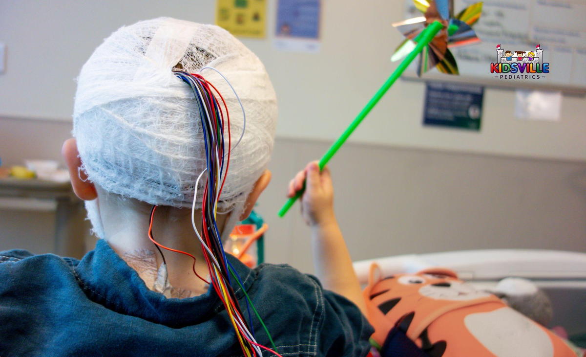 A child with cords and a gauze bandage wrapped around their head.