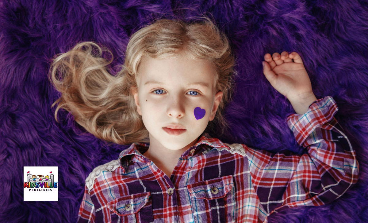 A girl lying down on a purple bed with a purple heart on her left cheek, indicating support for patients of epilepsy.