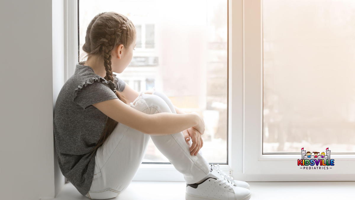 Lonely Little Girl near Window Indoors.