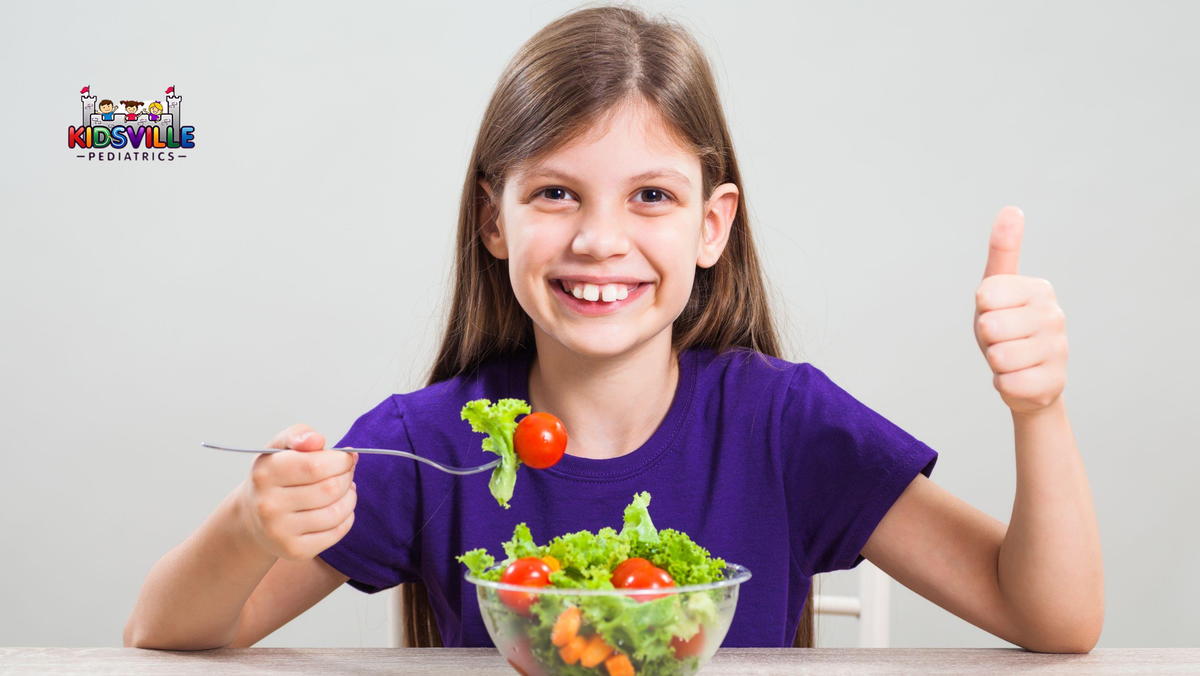 A young girl eating salad and liking it.