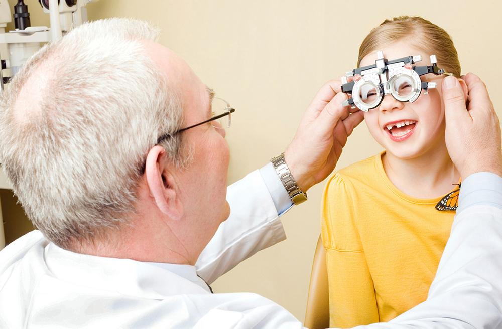 optometrist with child during an eye exam to treat strabismus