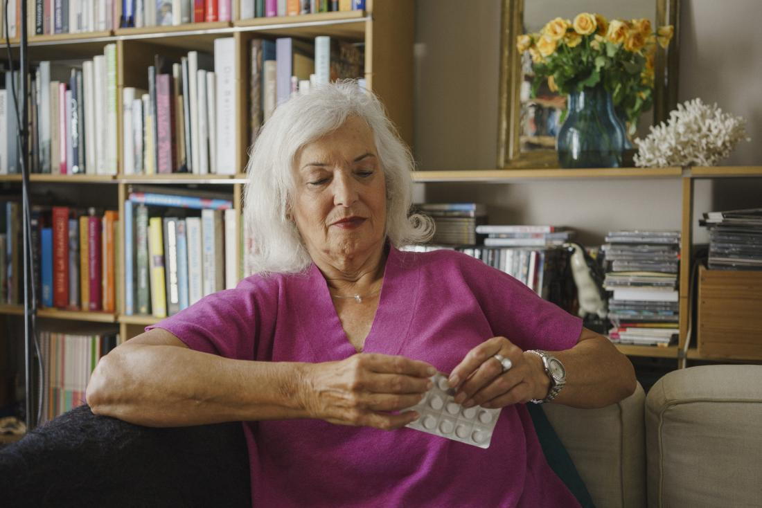 older woman about to take medication